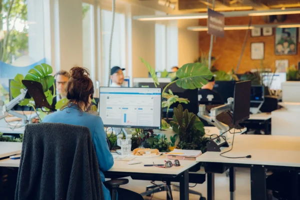 Collega werkt aan een bureau in het open kantoor van Stuurlui